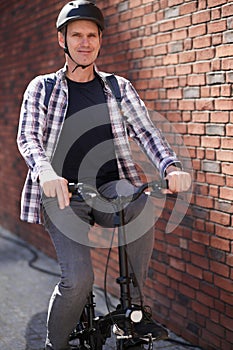 Man on a city bicycle against red brick wall
