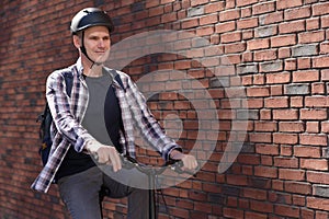 Man on a city bicycle against red brick wall