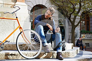 Man in city, bicycle and cellphone with travel, carbon footprint and communication with tech and cycling. Eco friendly