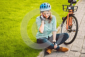 Man and city rolling bicycle, environmentally friendly transport. Beautiful young caucasian woman worker sitting resting on the gr