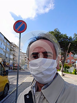 Man in city street wearing face mask protective for spreading of Coronavirus Disease. Portrait of man with surgical mask on face a