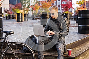 Man in city using laptop