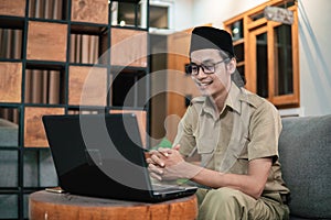 man in civilian uniform looking screen monitor while use laptop