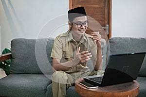 man in civilian uniform use laptop and smartphone while sitting with hand gestures to explain