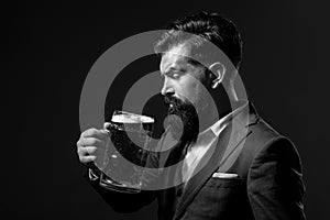 Man in classic suit drinking beer. Bearded guy in business outfit looks happy and satisfied. Portrait profile of man