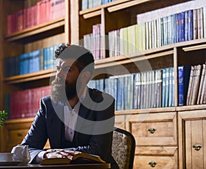 Man in classic suit sits in vintage interior, library,