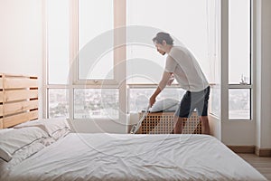 Man clean his bedroom apartment with mop.