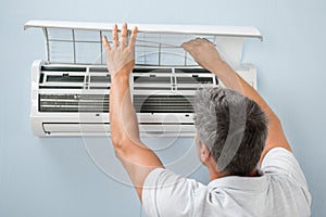 Man cleaning air conditioning system
