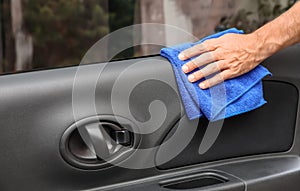 Man cleaning automobile door with duster, closeup