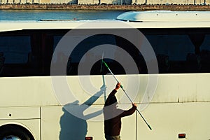 A man cleaning a bus with a squeegee