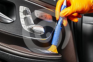 A man cleaning car with cloth and brush. Car detailing. Selective focus. Car detailing. Cleaning with brush. Worker cleaning. Brus