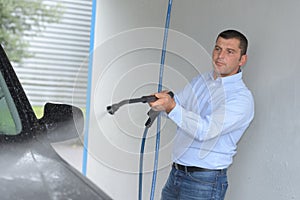 Man cleaning car with hose