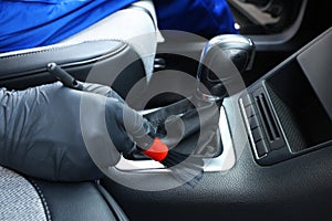 Man cleaning car interior with brush, closeup