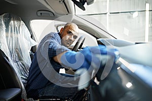 A man cleaning car interior, car detailing in Carwash service