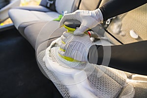 A man cleaning car interior by use foam chemical  and scrubbing machine
