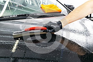 A man cleaning car with microfiber cloth, car detailing or valeting concept. Selective focus. Car detailing. Cleaning with spong