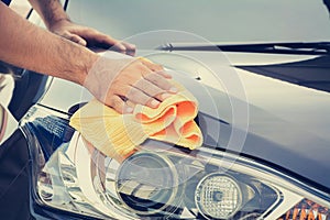 A man cleaning car with microfiber cloth photo