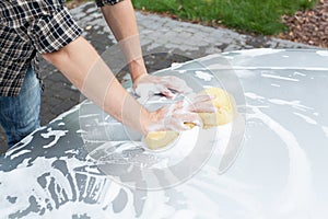 Man cleaning car's bonnet