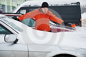 Man cleaning car from snow