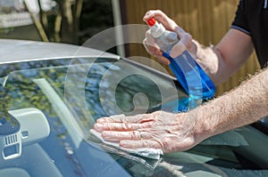 Man cleaning a car windshield
