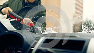 Man cleaning car windshield of ice