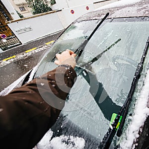 Man cleaning car windshields wipers before driving