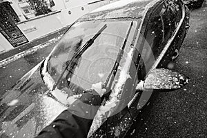 Man cleaning car windshields wipers before driving