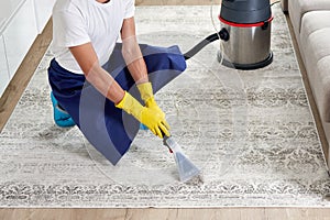 Man Cleaning Carpet In The Living Room Using Vacuum Cleaner At Home. Cleaning service concept