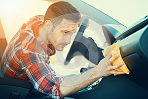 Man cleaning the dashboard of his car