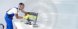Man Cleaning Desktop Screen With Rag
