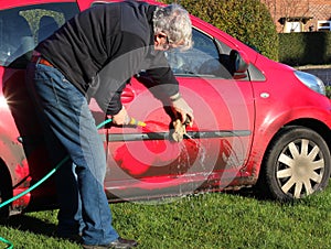 Man cleaning a dirty car.