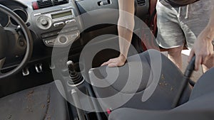 Man cleaning dirty car interior with vacuum cleaner