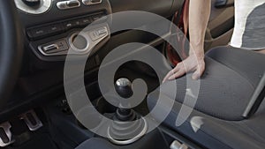 Man cleaning dirty car interior with vacuum cleaner