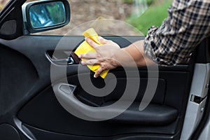 Man cleaning door in a car