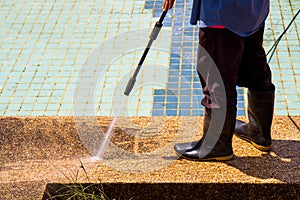 A man cleaning floor with high pressure water jet