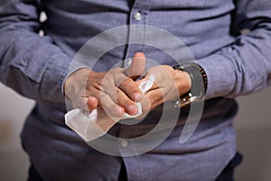 Man cleaning hands with wet wipes