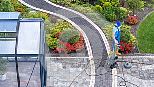 Man Cleaning His Backyard Garden Paths Using Pressure Washer