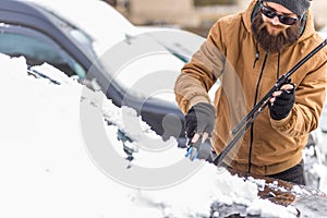 Man cleaning his car from snow
