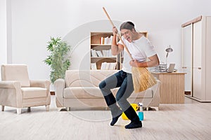 The man cleaning home with broom