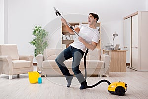 The man cleaning home with vacuum cleaner