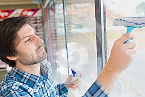 man cleaning inside window pane