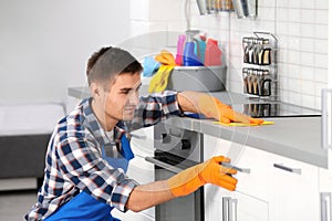 Man cleaning kitchen counter with rag