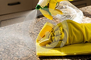 Man cleaning kitchen counter with solution to kill viruses and bacteria