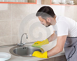 Man cleaning kitchen sink