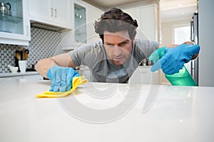 Man cleaning kitchen worktop at home