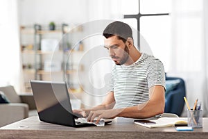 Man cleaning laptop with wet wipe at home office