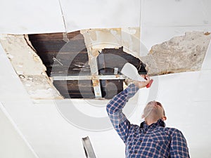 Man cleaning mold on ceiling.