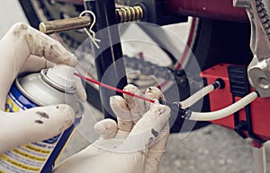 Man cleaning motorcycle chain with special device brush