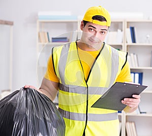 Man cleaning the office and holding garbage bag