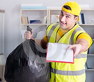 Man cleaning the office and holding garbage bag